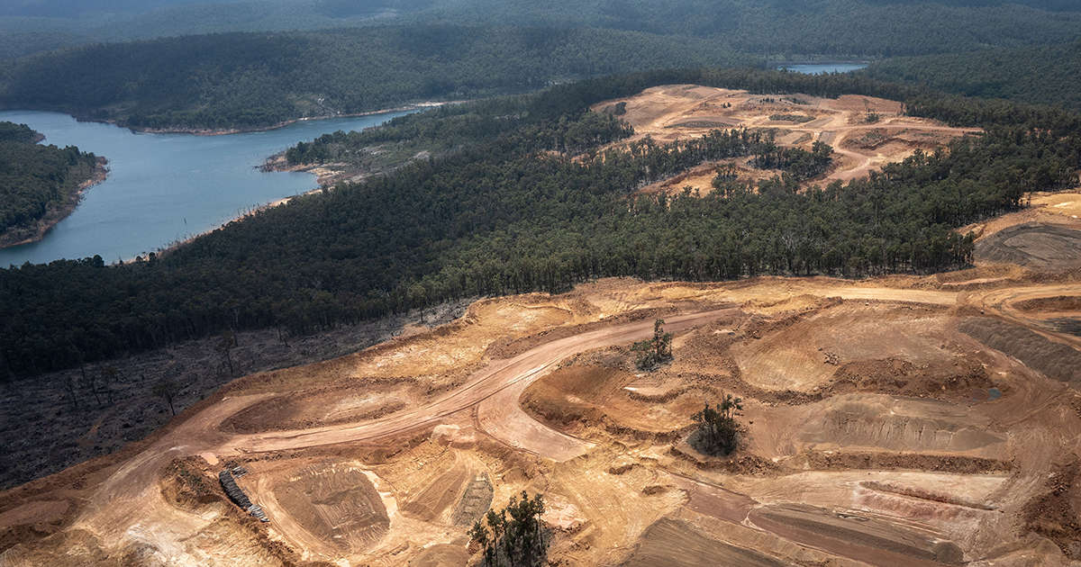 Aerial photo of forests cleared for Alcoa's bauxite strip mining next to river. 
