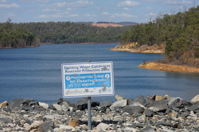 Clearing visible from Serpentine Dam. A sign in the foreground notes the Reservoir Protection Zone